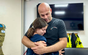 This handout image released by the Israeli army, shows Israeli former hostage Hila Rotem-Shoshani (13) embracing her uncle at a hospital in Israel after being released by Hamas, amid an exchange operation of hostages against prisoners between Hamas and Israel, on 26 November 2023.