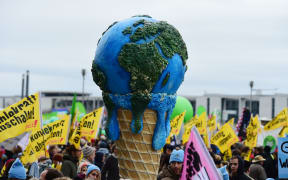 A melting planet in an ice cream cone carried during the climate change march in  Berlin, Germany.