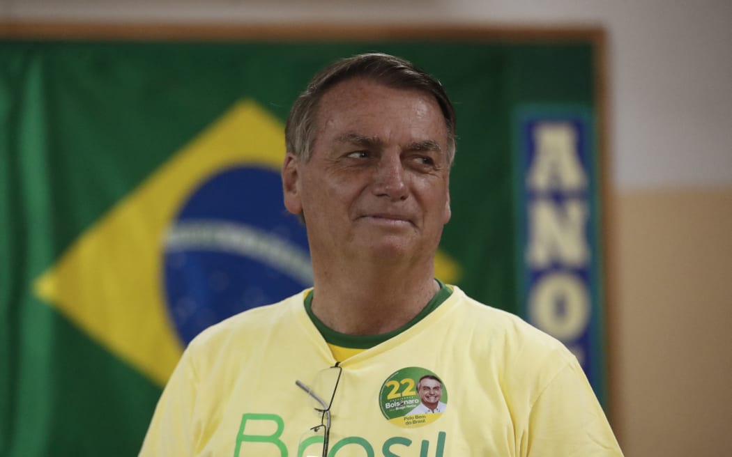 Brazilian President and re-election candidate Jair Bolsonaro looks on as he votes at a polling station in Rio de Janeiro, Brazil, on October 30, 2022, during the presidential run-off election. - After a bitterly divisive campaign and inconclusive first-round vote, Brazil elects its next president in a cliffhanger runoff between far-right incumbent Jair Bolsonaro and veteran leftist Luiz Inacio Lula da Silva. (Photo by BRUNA PRADO / POOL / AFP)