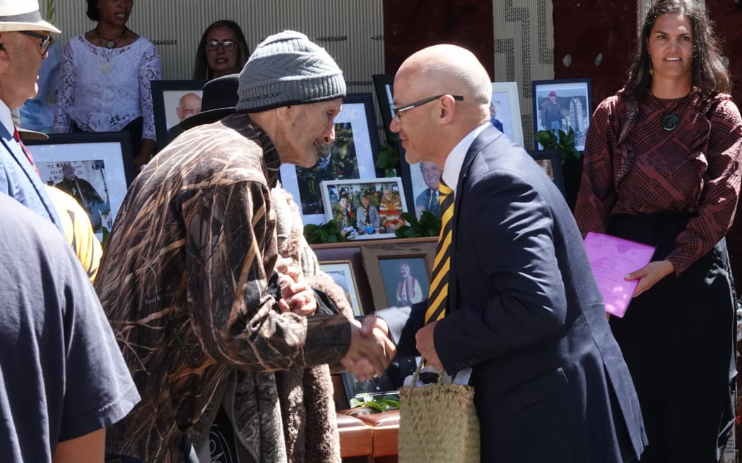 Te Ihutai kaumātua Pai Tahere accepts a copy of the Waitangi Tribunal report, on behalf of Hokianga claimants, from presiding officer Craig Coxhead.