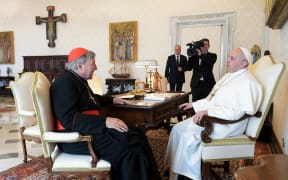 Pope Francis talks with Cardinal George Pell