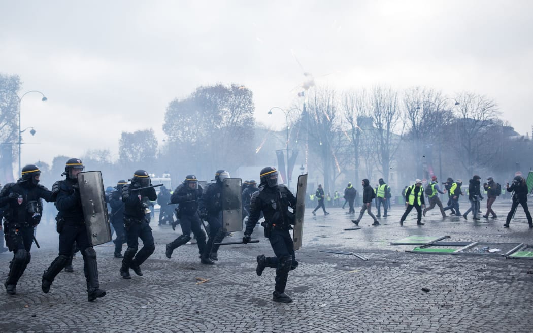 Police officers take their positions during clashes with people wearing yellow vests, a symbol of a French drivers' rally against higher fuel prices, in the Champs-Elysees, in Paris, France, November 24, 2018.