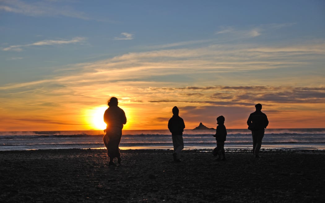 A tourist family enjoys the sunset at Rapahoe Beach near Greymouth (file photo)