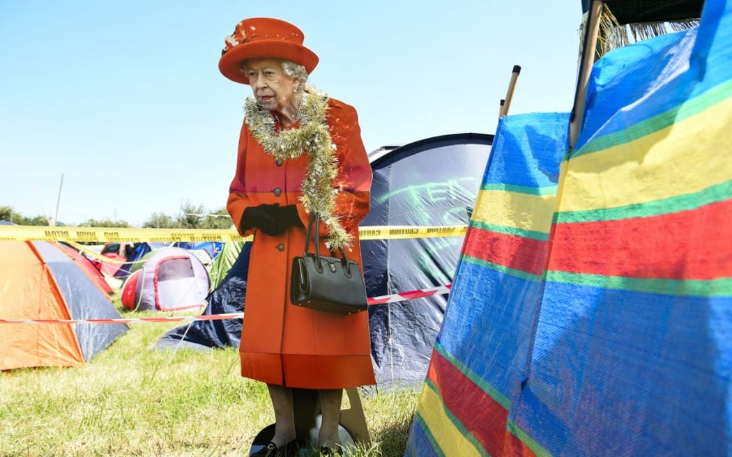A board depicting Britain's Queen Elizabeth II is seen on the camping site during the Glastonbury festival in the village of Pilton, in Somerset, South West England, on June 22, 2022. - More than 200,000 music fans and megastars Paul McCartney, Billie Eilish and Kendrick Lamar descend on the English countryside this week as Glastonbury Festival returns after a three-year hiatus. The festival takes place from June 22 to June 26, 2022. (Photo by ANDY BUCHANAN / AFP)