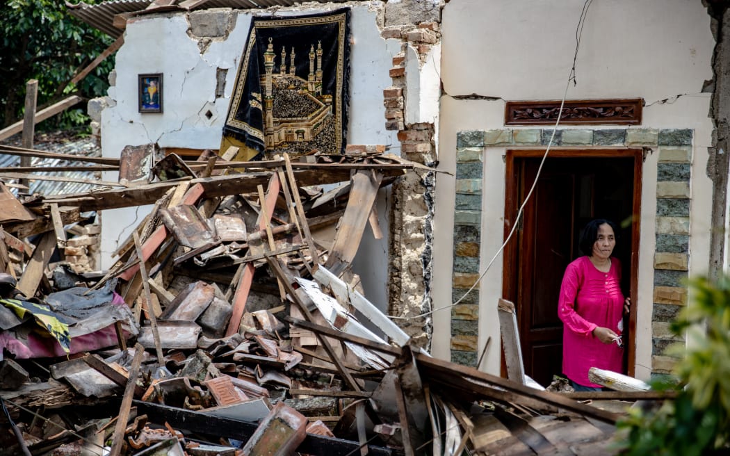 A woman stands in a building damaged in the 5.6 magnitude earthquake struck the region of Cianjur in West Java, Indonesia on November 22, 2022.