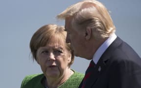 German Chancellor Angela Merkel confers with US President Donald Trump.