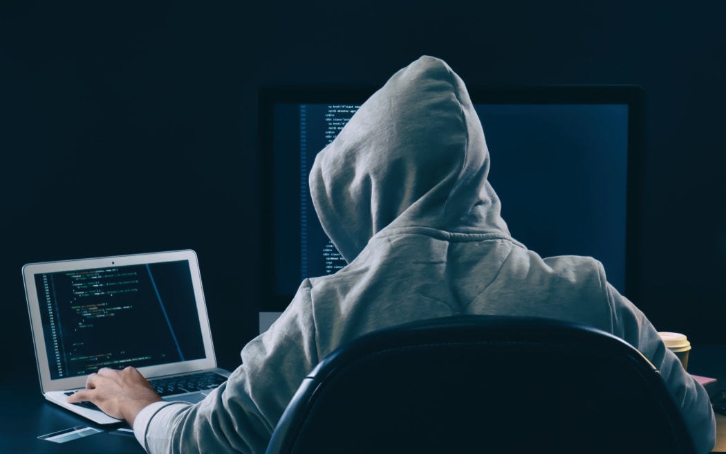 Man wearing hoodie hacking server in gloomy room