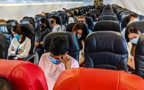Passengers on board a plane with masks.
