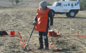 A UN expert works to dispose of landmines.