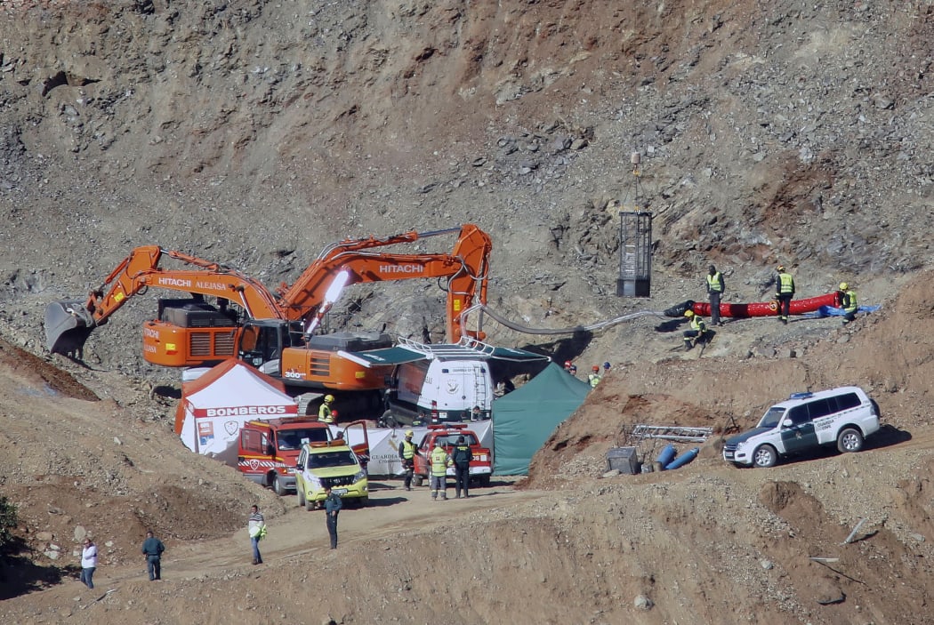 In this photo taken on Thursday, Jan. 24, 2019, drill and excavating machinery work on mountain next to a deep borehole to reach a 2-year-old boy trapped s near the town of Totalan in Malaga, Spain.