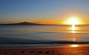 Auckland has much better weather than the capital and a beautiful environment, says Phil Goff. (Image shows sun rising behind Rangitoto Island)