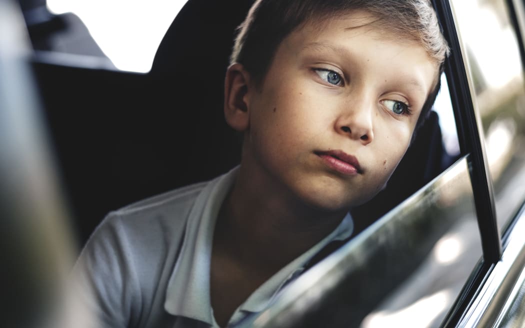 Boy / Child looking out of car window.