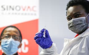 A healthcare worker holds up a SINOVAC Covid-19 vaccine before administering it on a minor during the Numolux/SINOVAC Peadiatric Covid-19 Vaccine Clinical Trial at the Sefako Makgatho Health Sciences University in Pretoria, on September 10, 2021. )