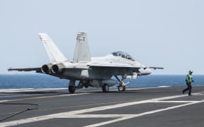 A United States F/A-18F Super Hornet lands on aircraft carrier USS George H.W. Bush after carrying out strikes on IS targets.