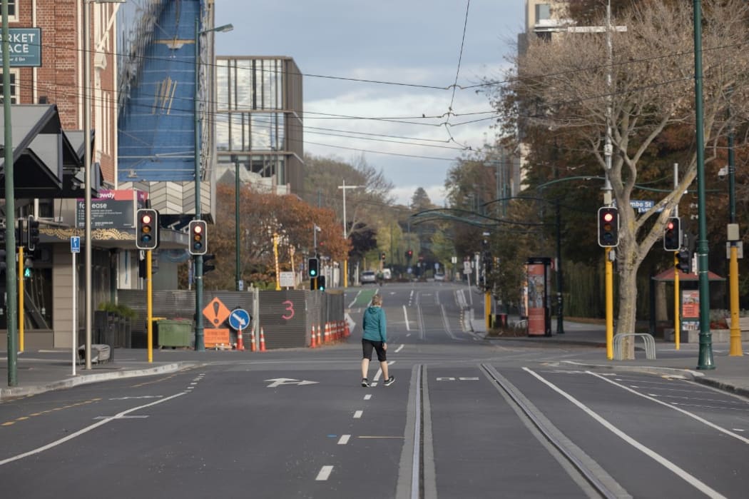 A woman walks across an empty intersection in Christchurch, New Zealand, on April 16, 2020. New Zealand is currently in alert level four.