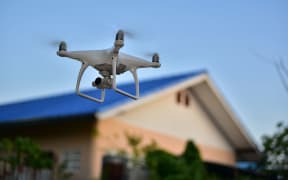 Drone take off from land and flying front of home for take aerial photo.