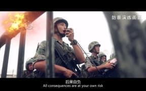 This screengrab taken from undated handout three-minute promotional video received on August 1, 2019 from China's People's Liberation Army (PLA) Hong Kong Garrison shows PLA soldiers warning "protesters" during an "anti-riot" drill in Hong Kong.