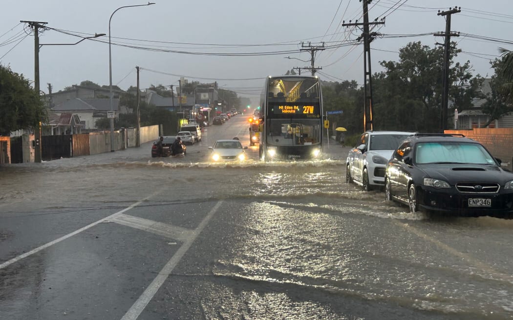 The bus to Mt Eden makes its way through floodwaters