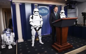 US Press Secretary Josh Earnest speaks to the press in the briefing room at the White House flanked by Star Wars characters R2D2 and Storm Troopers.
