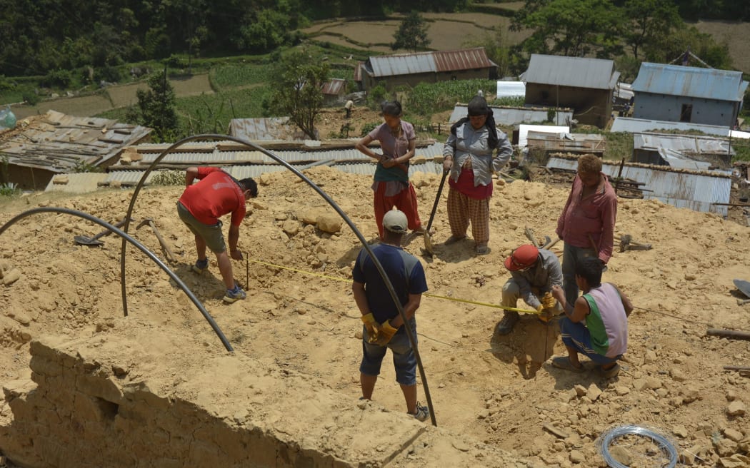 Residents of a village in Nepal's Kavre district work to build shelters for those left without houses. 23 May 2015.