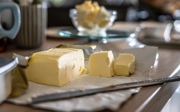 A piece of butter, with several pieces waiting for a good amount of toast