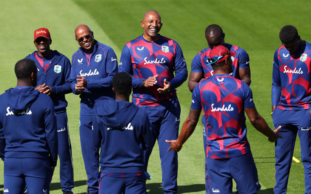 West Indies' head coach Phil Simmons (C) talks to his player ahead of the warm up before the start of play on the fourth day of the second Test cricket match against England at Old Trafford in Manchester on July 19, 2020.