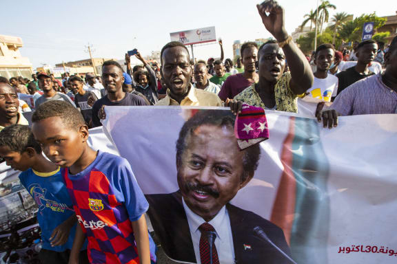 Protesters in Khartoum on Saturday carry a banner showing ousted PM Abdullah Hamdok, and demanded and end to the coup.