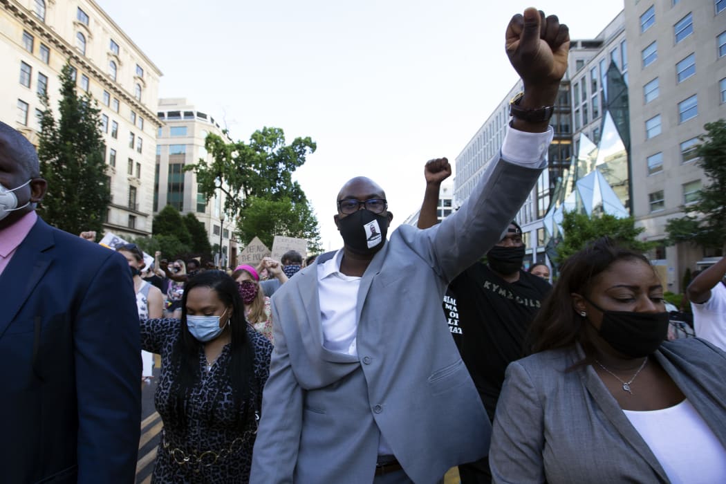 Philonise Floyd (centre), George Floyd's brother, holds up his fist as he marches with others near the White House, to protest police brutality and racism