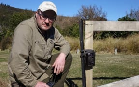 Orokonui's conservation manager, Elton Smith, with one of the motion cameras used to spot the stoat.