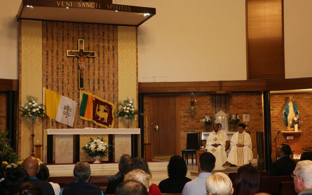 Father Jue Algama (L) from St Mary's Catholic Church in Northcote led the service.