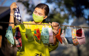 16-year-old Yuni Cheng Wiik hangs out colourful face masks that she made for her family and friends on 20 April 20, 2020 in Nesodden, a suburb across the fjord of Oslo, Norway.