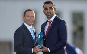 Prime Minister Tony Abbott (left) presents Adam Goodes with the Australian of the Year Award.