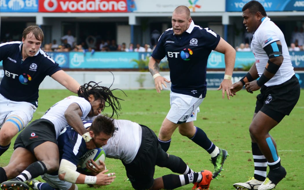Scotland's Ross Road (3rd L) driving through Fiji's defence for the try line during the one-off test in Suva.