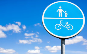 Bicycle and pedestrian shared route sign on the sky background