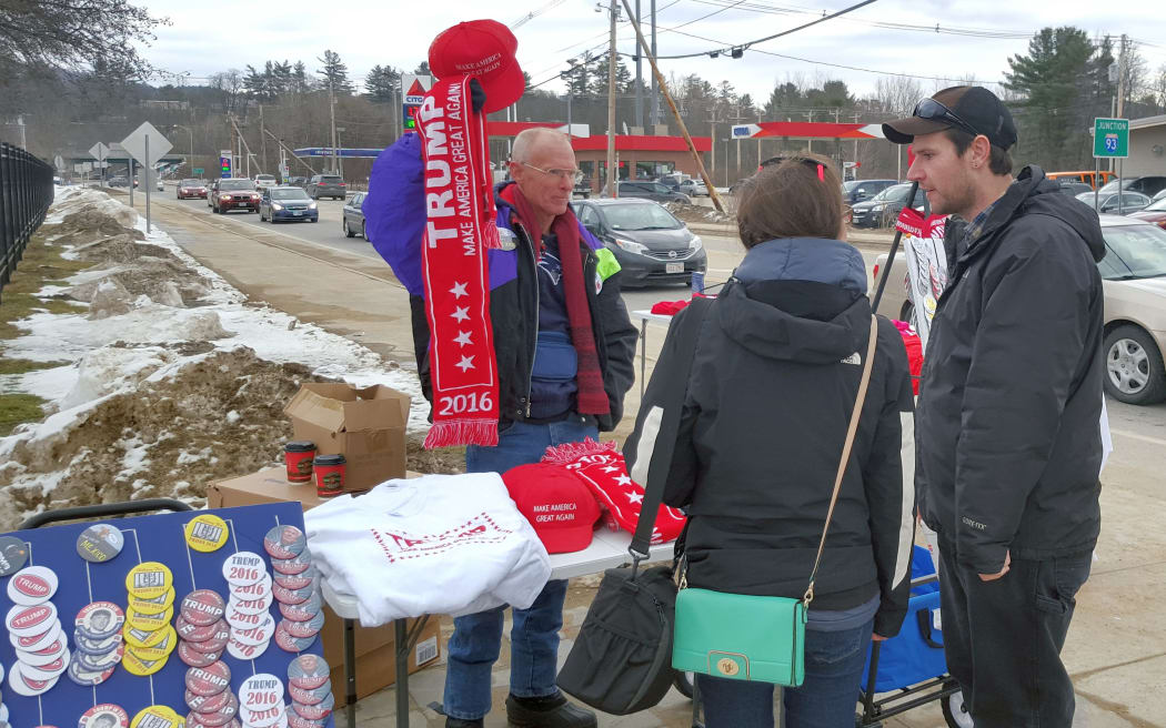 Salesman holds up Trump scarf at outside stall