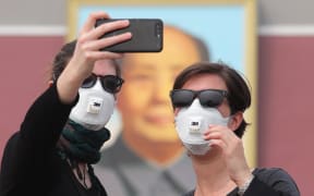 Foreign tourists wearing face masks against air pollution visit the Tian'anmen Square in heavy smog in, China.