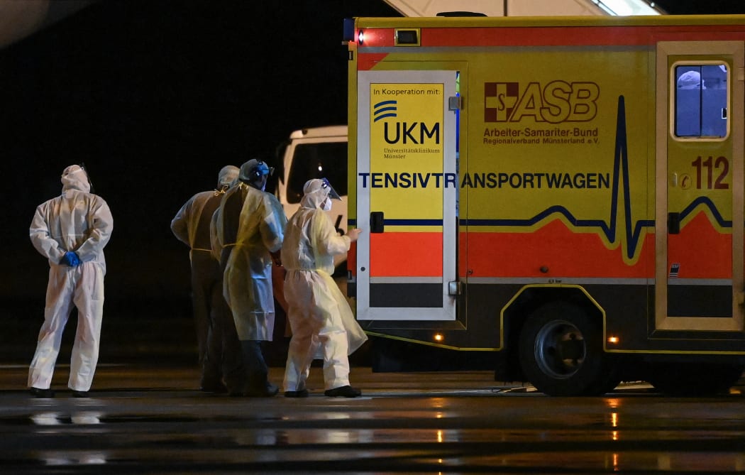 Medics transporting patients infected with Covid-19 to other intensive care units (ICU) from a MedEvac of the German armed forces Bundeswehr to an ambulance to move to other intensive care units (ICU) in the country, at Muenster Osnabruck Airport, northern Germany on November 26, 2021.