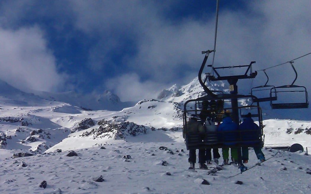 Skiers on a chairlift at the Turoa ski field.