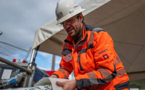 Max Vollenbroich of German firm Amex-Sanivar helps guide the folded and taped high strength liner towards the sludge pipe.