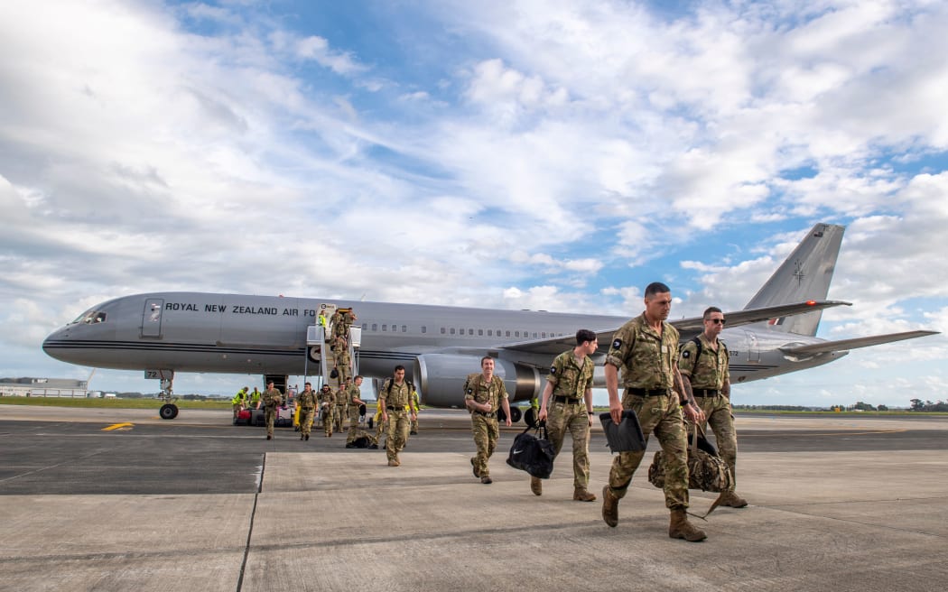 Nowozelandzcy żołnierze wysiadają z samolotu w bazie sił powietrznych Ohakia w niedzielę, 11 grudnia 2022 r.