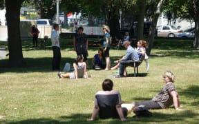 Office workers in the shade next to the Avon River in Christchurch.