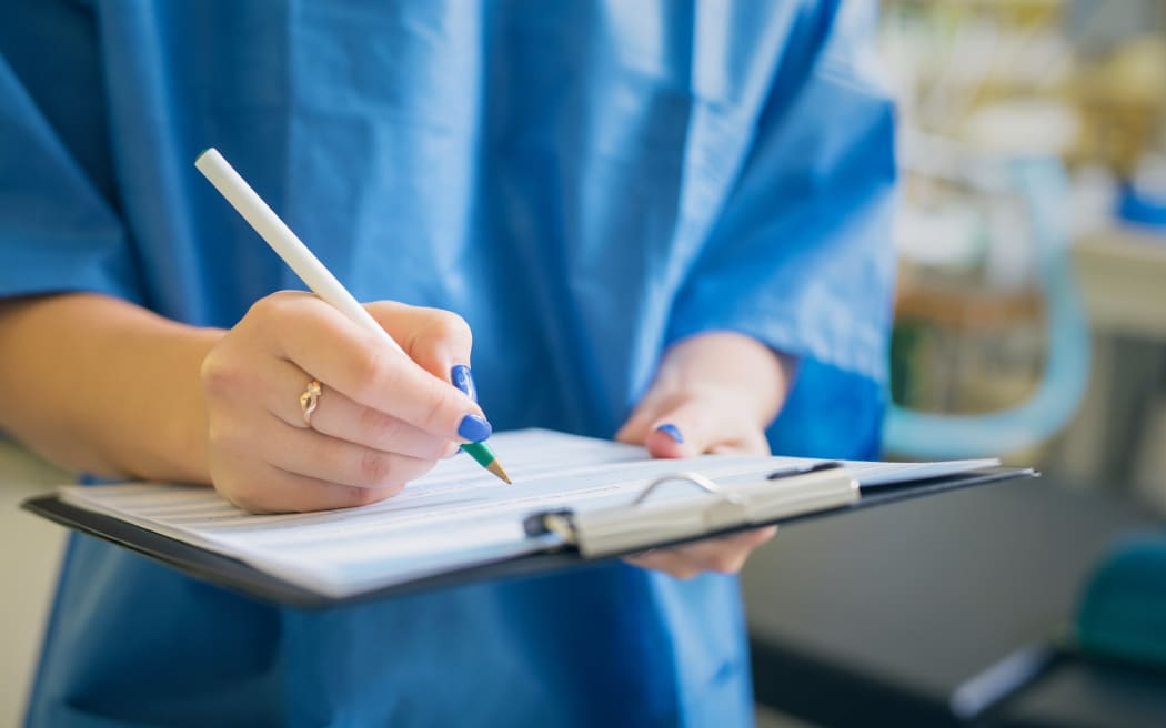 Medical professional signing a document.