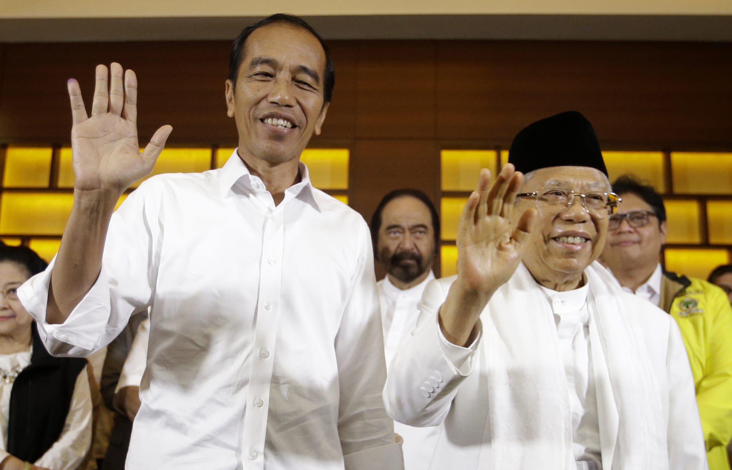 Indonesian President Joko Widodo, left, and his running mate Ma'ruf Amin wave after a press conference in Jakarta, Indonesia, on 17 April, 2019.