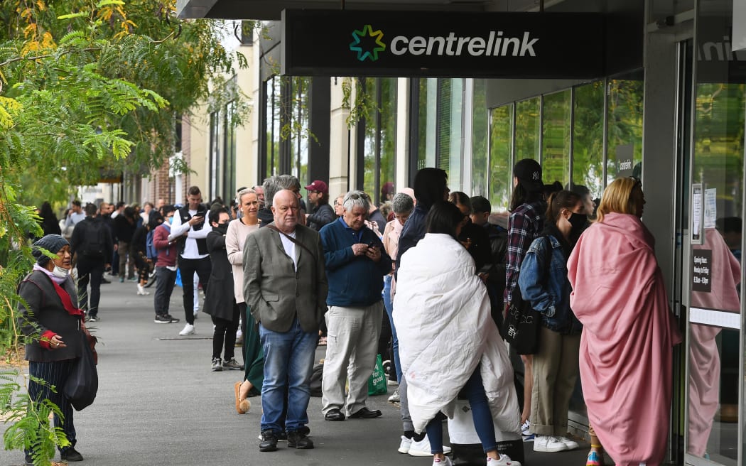Hundreds of people queue outside an Australian government welfare centre, Centrelink, in Melbourne.