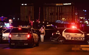 Police form a perimeter around the road leading to the Mandalay Bay hotel.