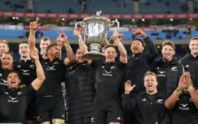 Cam Roigard of New Zealand holds the Bledisloe Cup as Sam Cane and the All Blacks celebrate after they won the New Zealand All Blacks v Australian Wallabies Bledisloe Cup and Rugby Championship test match at the MCG, Melbourne, Australia on Saturday 29 July 2023.