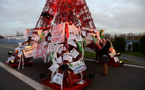An Eiffel Tower made of bistro chairs is seen covered in messages related to climate change at COP21.