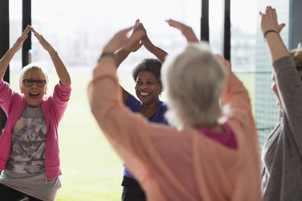 Happy active senior women exercising, stretching arms overhead in exercise class. (Photo by CAIA IMAGE/SCIENCE PHOTO LIBRARY / NEW / Science Photo Library via AFP)