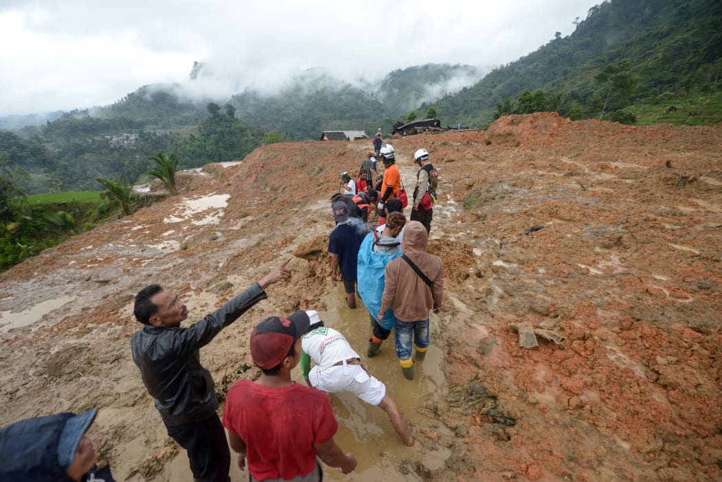 Rescue workers search for survivors at the site of a landslide triggered by heavy rain in Sukabumi, West Java province on January 1, 2019.