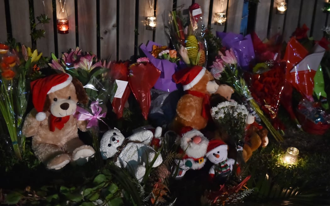 Flowers and stuffed toys near the scene where eight children were found dead in a house in Cairns, Australia.